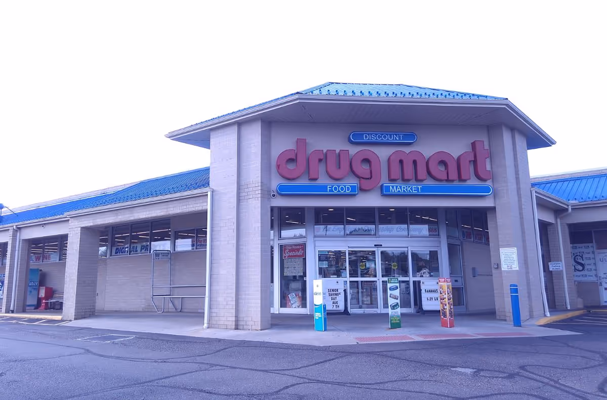 Front exterior of Discount Drug Mart storefront with pink sign and blue accents.