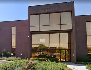 Front exterior of a Comfort Keepers Home Care facility with brick walls and large glass entrances.