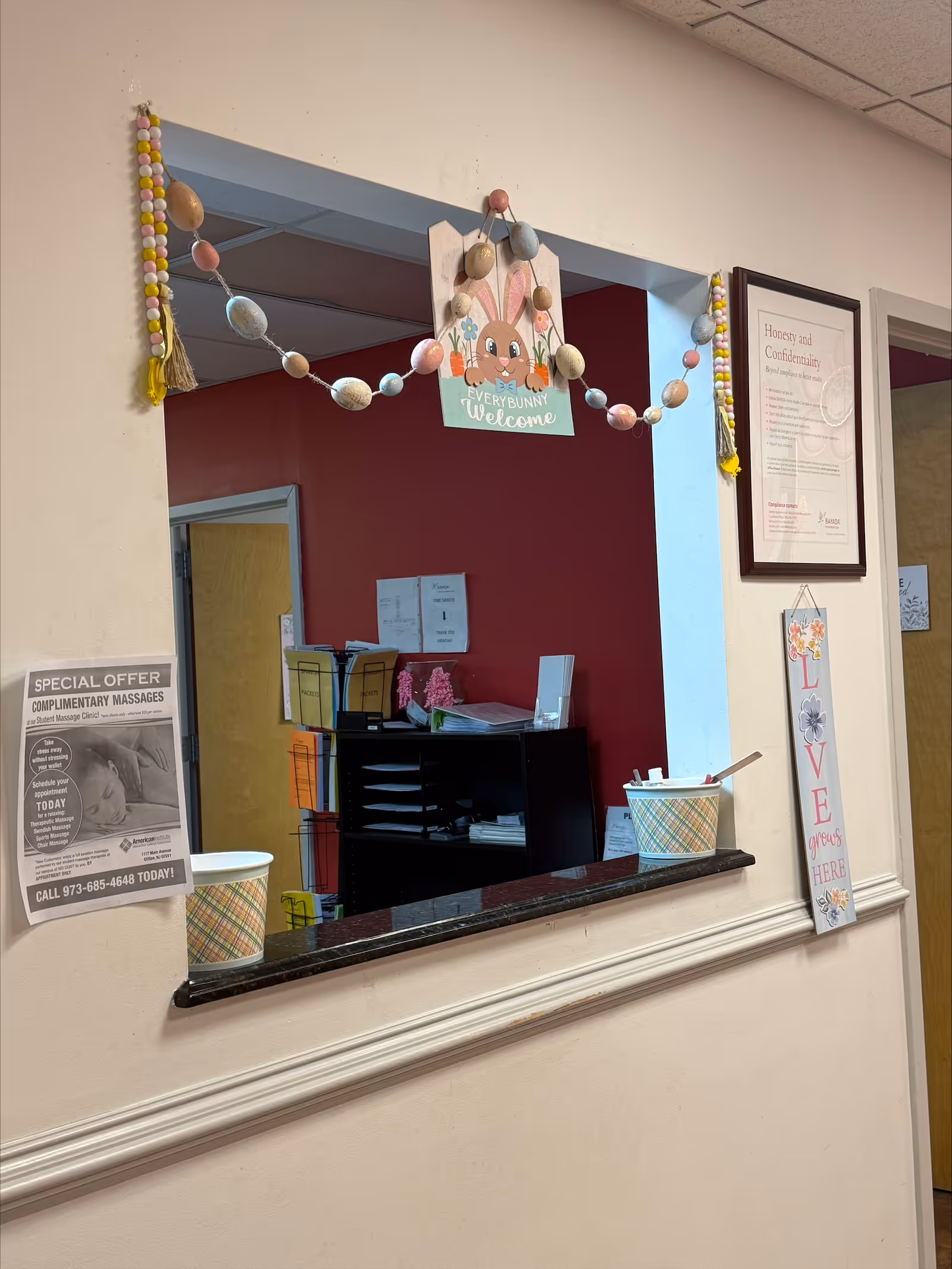 Interior front desk area with welcome banner, garland, and notices in a senior living facility.