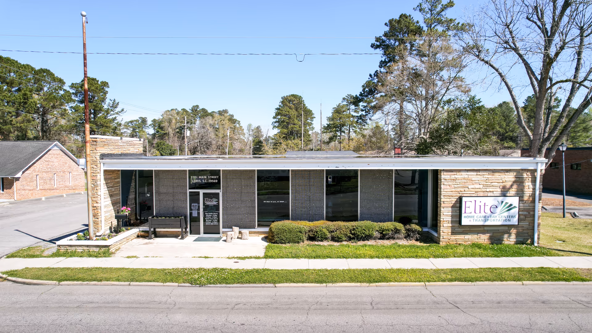 Single-story brick storefront with large windows and an Elite Home Care Centers sign on the front.