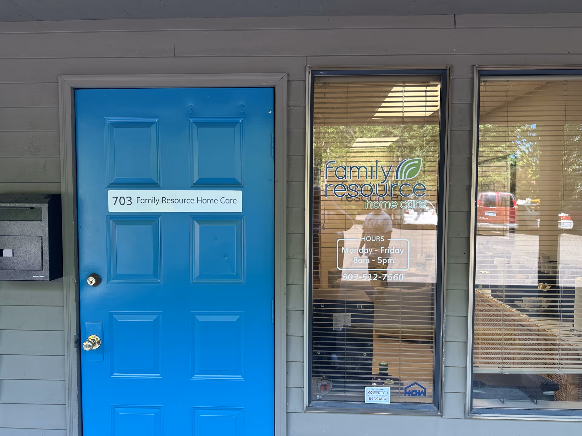 Blue entrance door beside glass storefront displaying Family Resource Home Care signage.