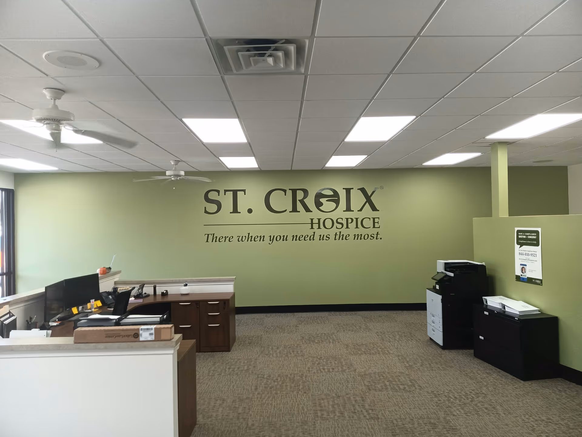 Reception area inside St. Croix Hospice featuring a front desk and office equipment.