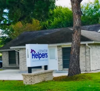 Exterior view of a Senior Helpers facility with a sign near the entrance.