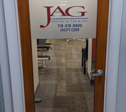 Doorway reveals JAG Physical Therapy sign and a tiled therapy room interior.