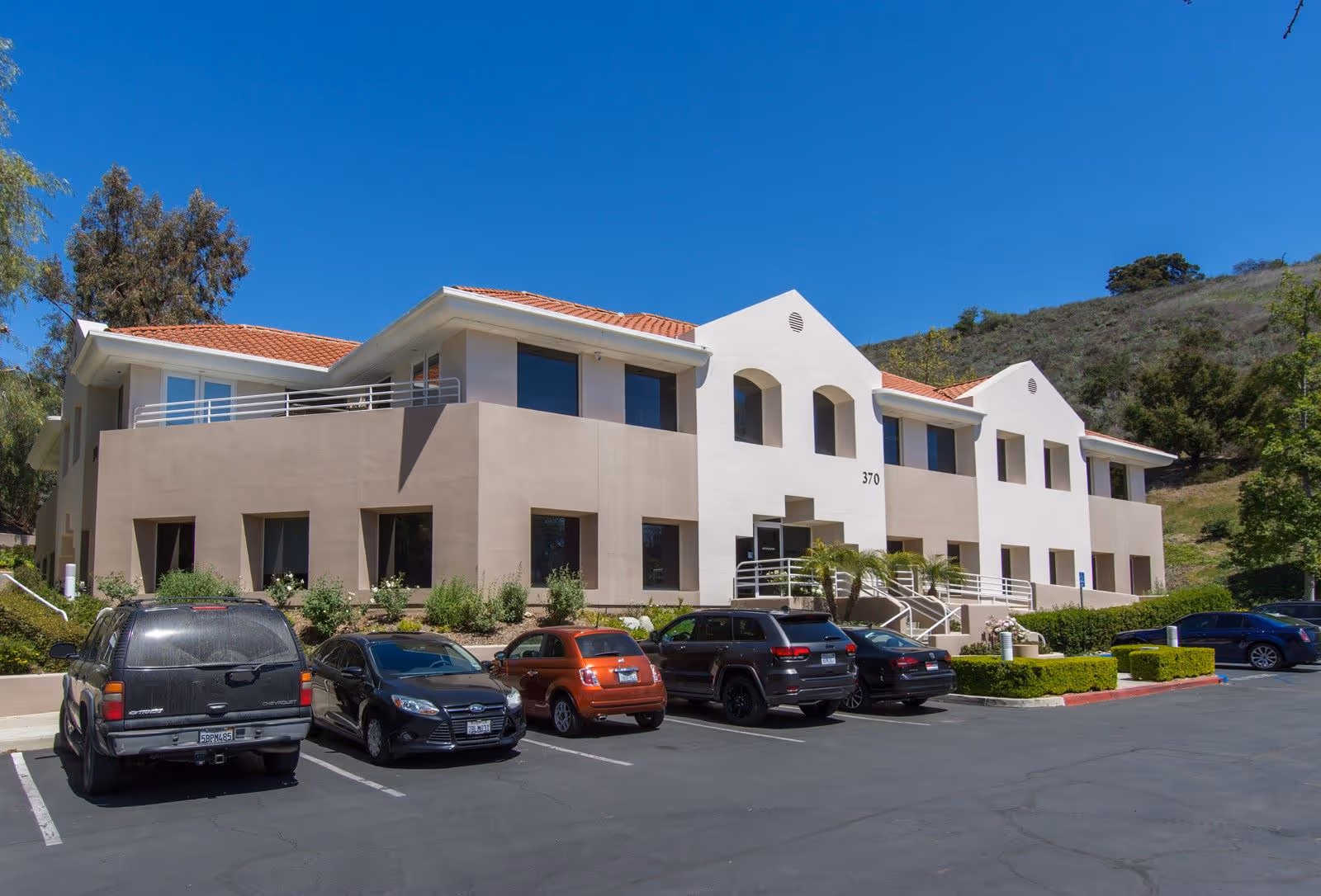 Exterior view of BrightStar Care facility with a tan and white building and parked cars