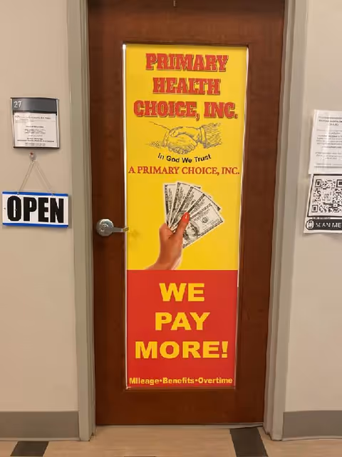 Doorway in a hallway features a bright yellow poster and an 'OPEN' sign.