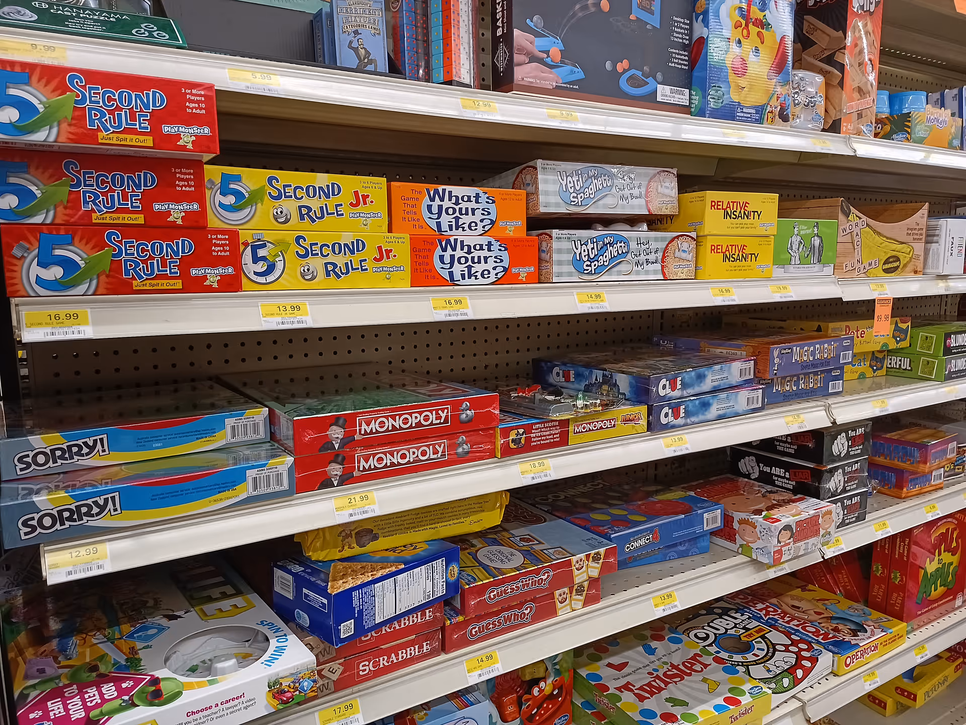 Shelves stocked with boxed board games and puzzles inside Discount Drug Mart.