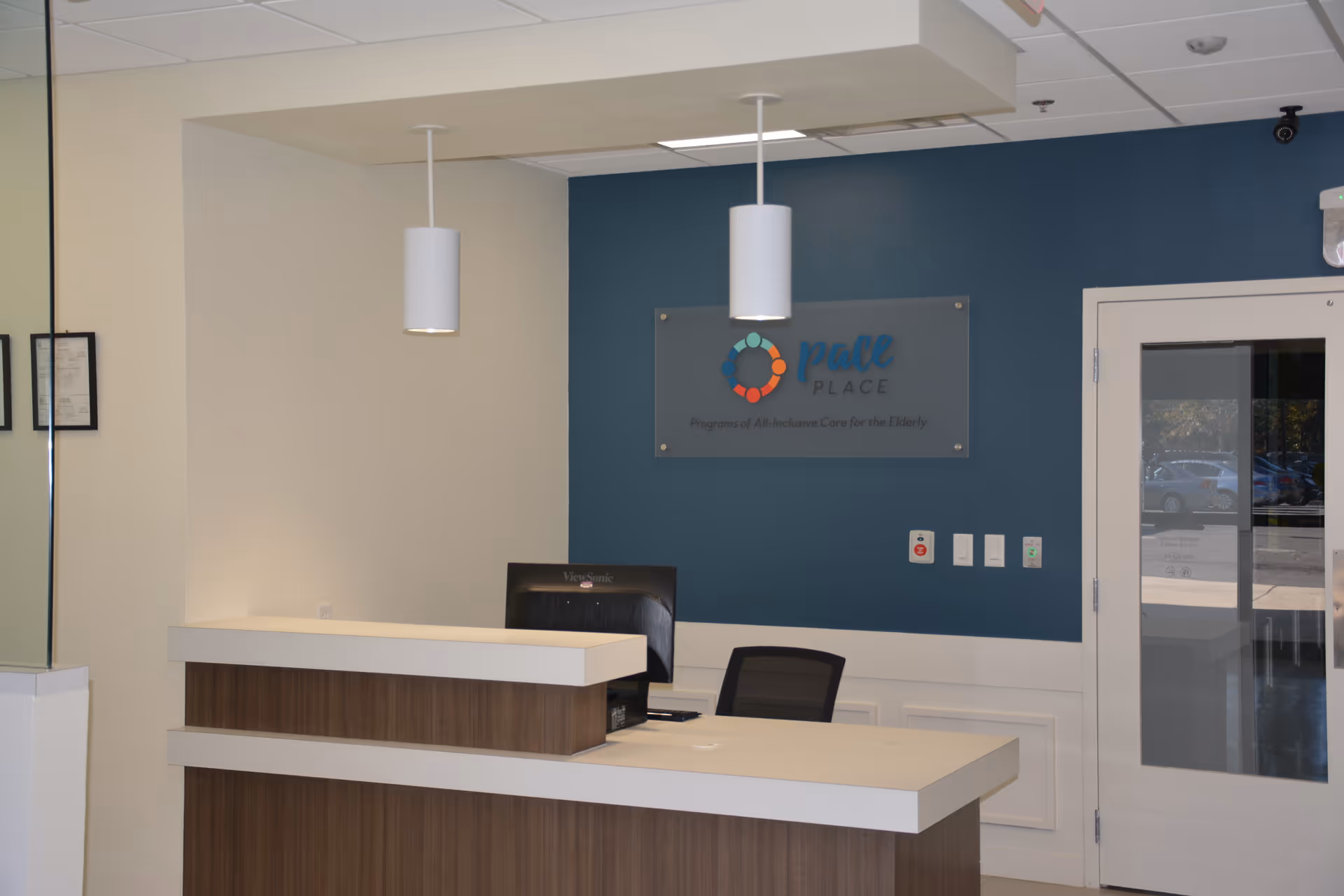 Reception desk in The PACE Place lobby with blue wall and sign.
