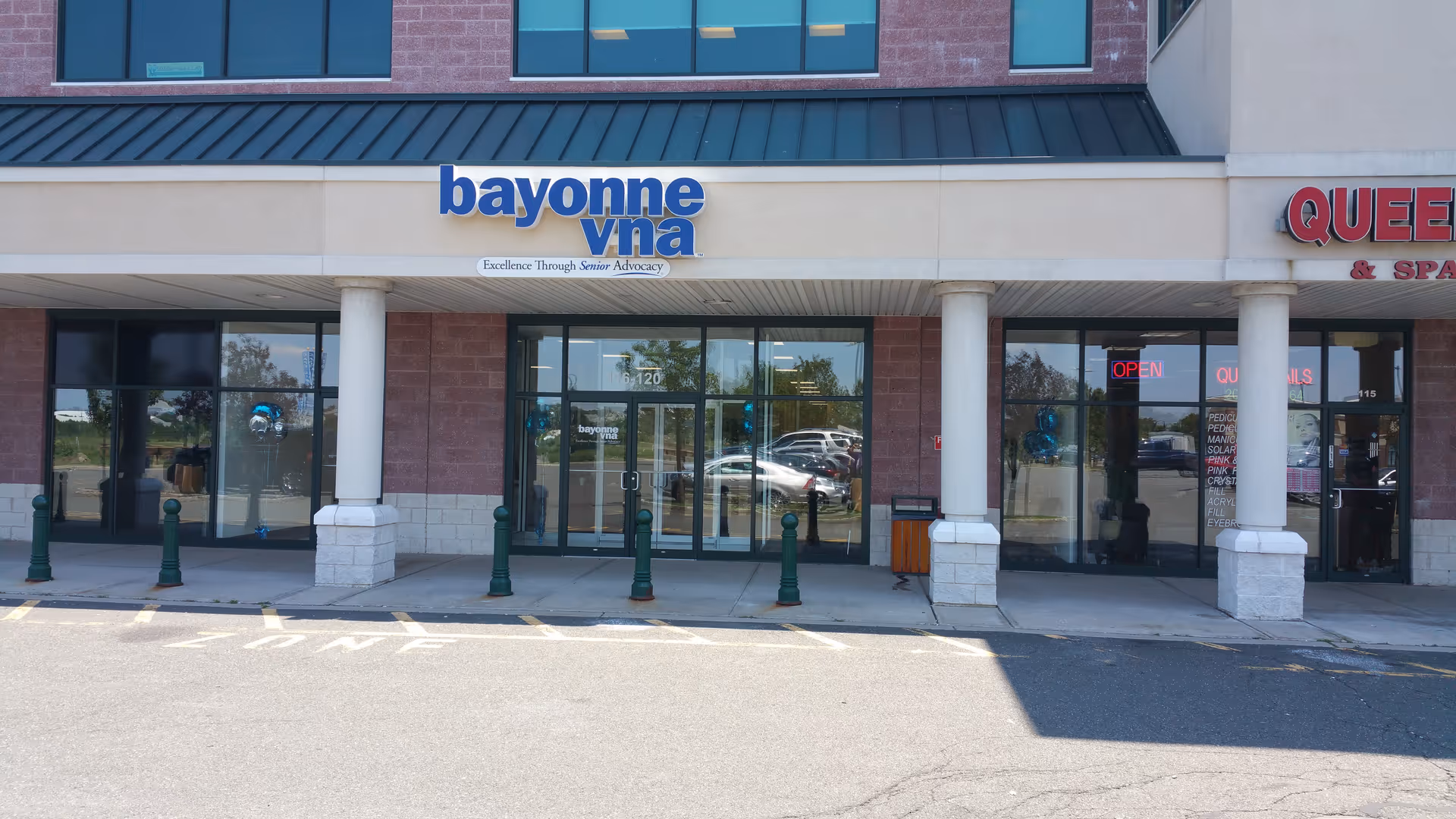 Exterior storefront with glass doors and blue signage reading bayonne vna.