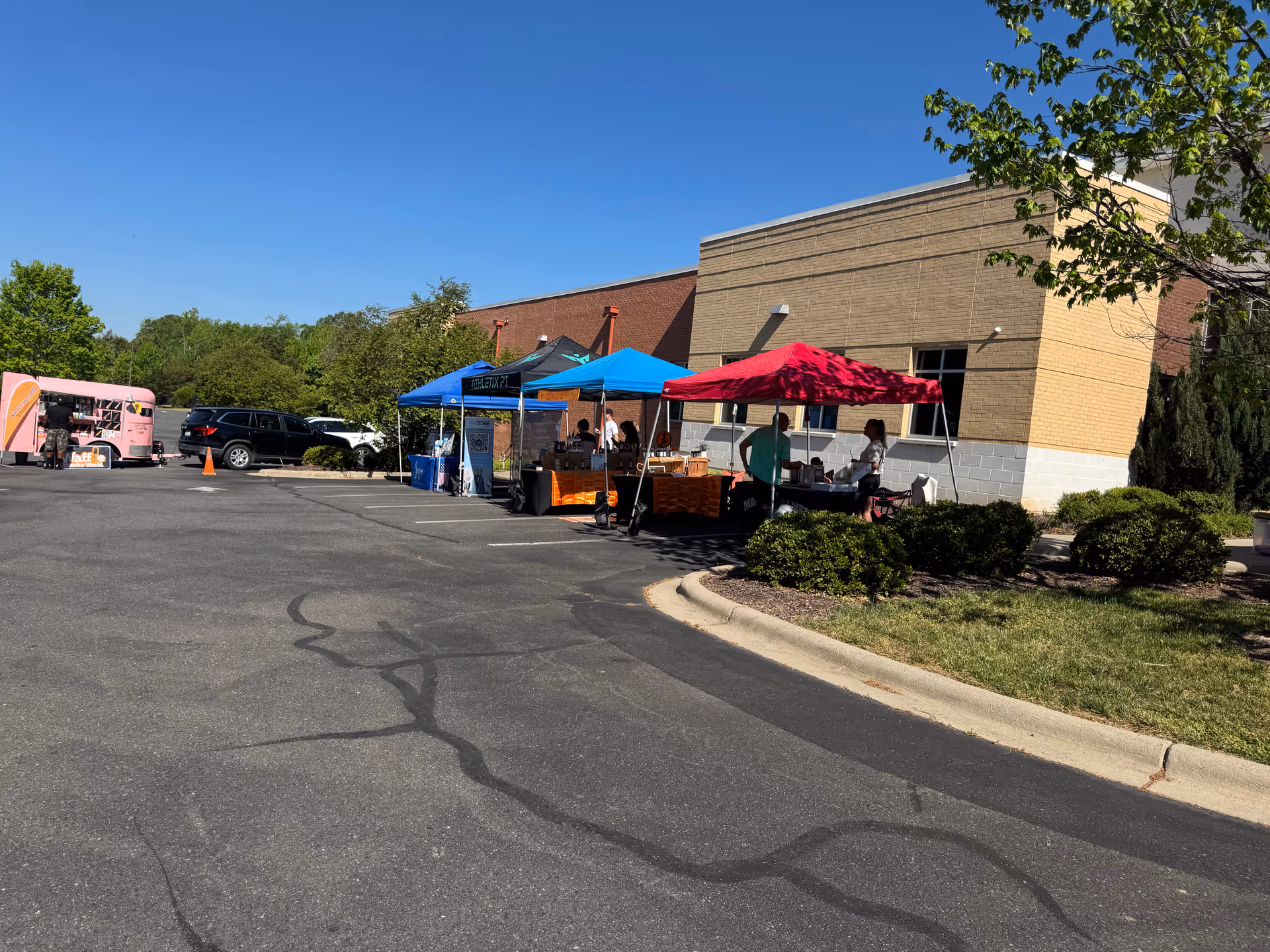 Outside a senior care facility, colorful tents and tables line a parking lot.
