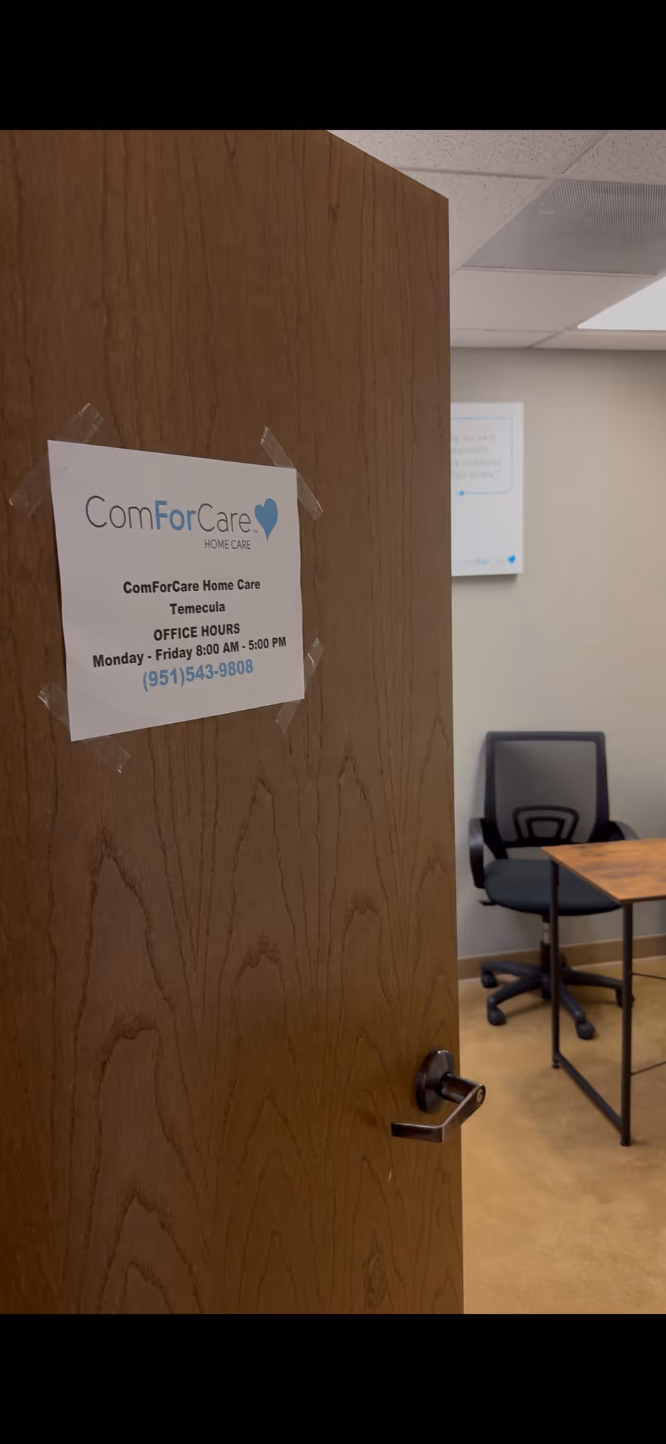 Open door reveals a small office with a sign for ComForCare Home Care.