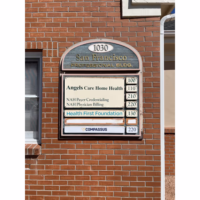 Brick building exterior with a rounded signboard listing Compassus and health providers.