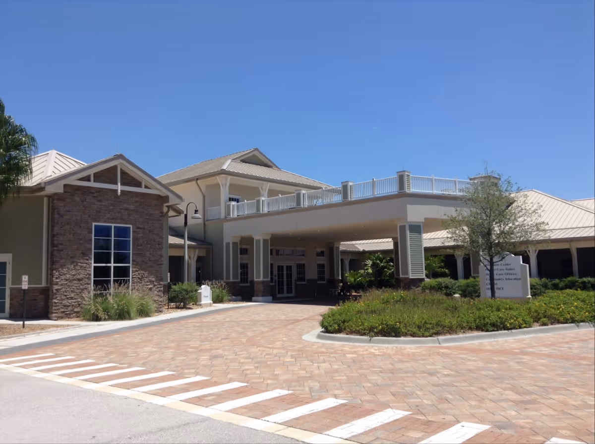 Hope Hospice exterior building with brick facade, landscaped entrance, and clear blue sky.