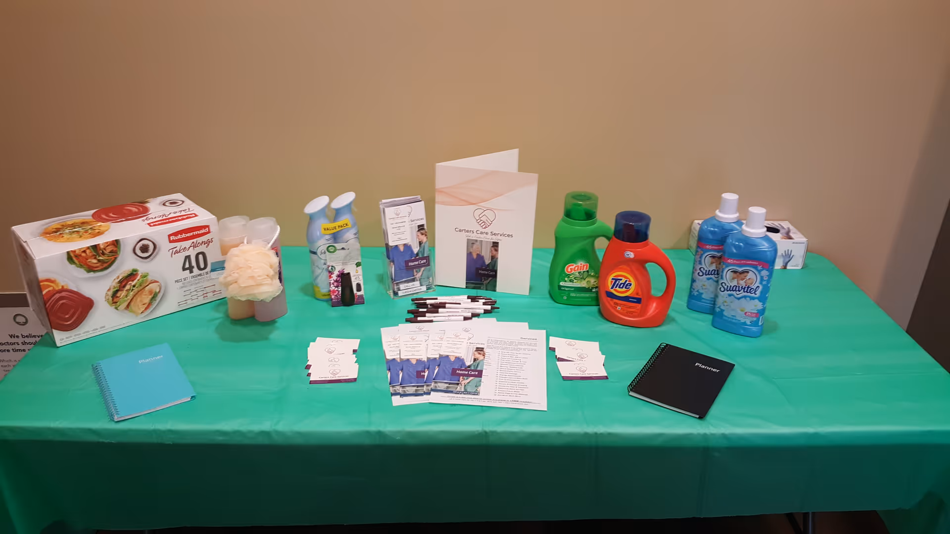 A green table displays Carters Care Services brochures and supplies indoors.
