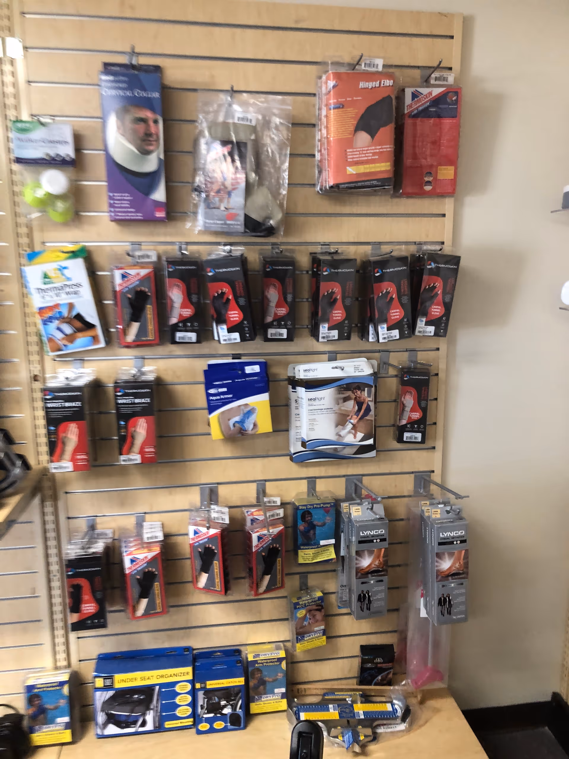 Wall-mounted pegboard displaying assorted medical braces and accessories.