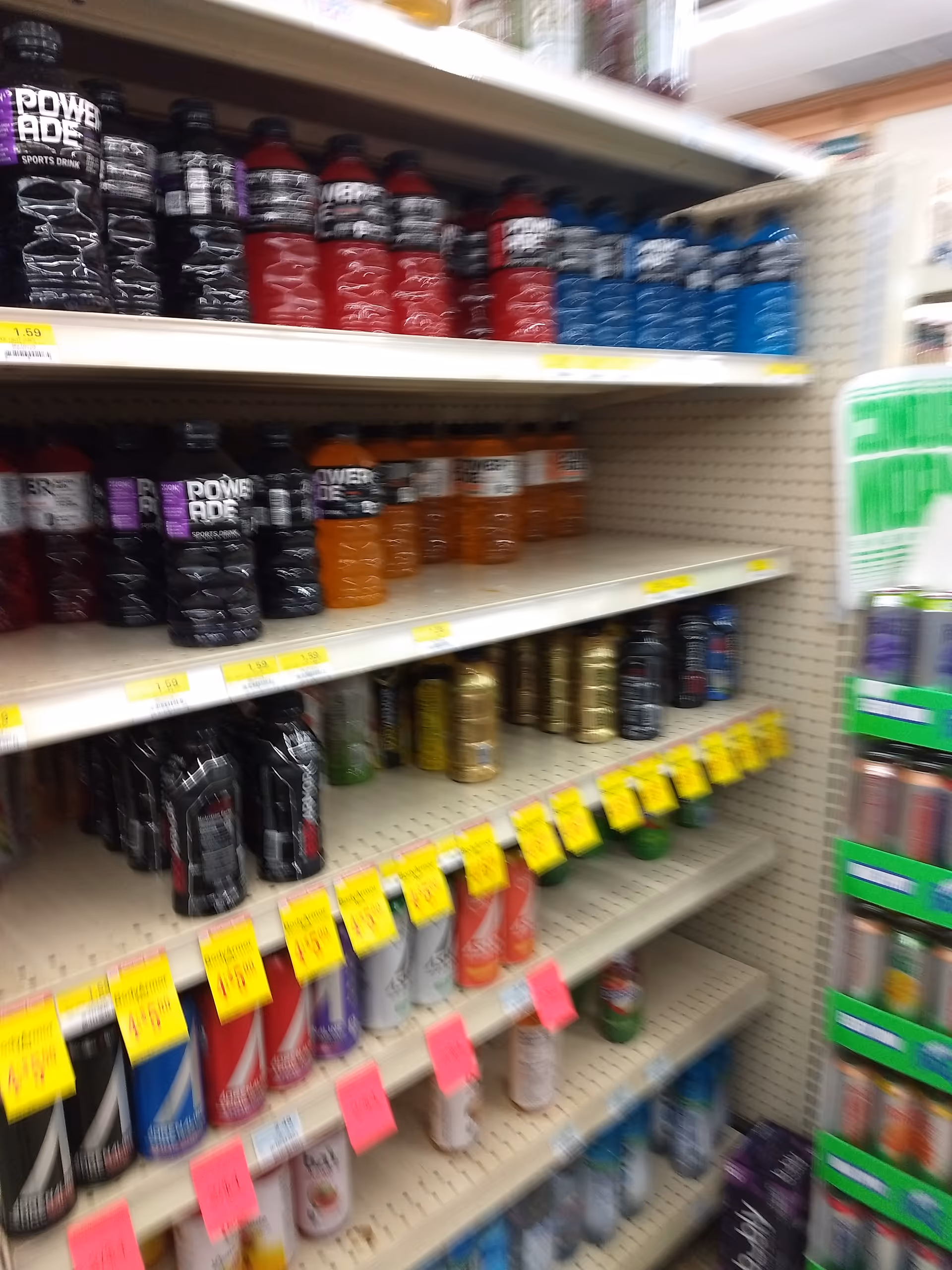 Aisle of bottled beverages on shelves inside Discount Drug Mart.