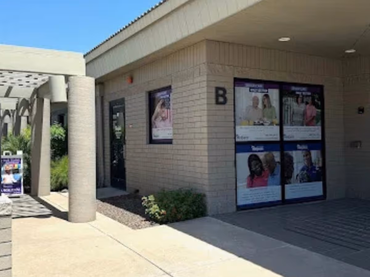 Exterior view of Senior Helpers facility entrance with windows and posters.