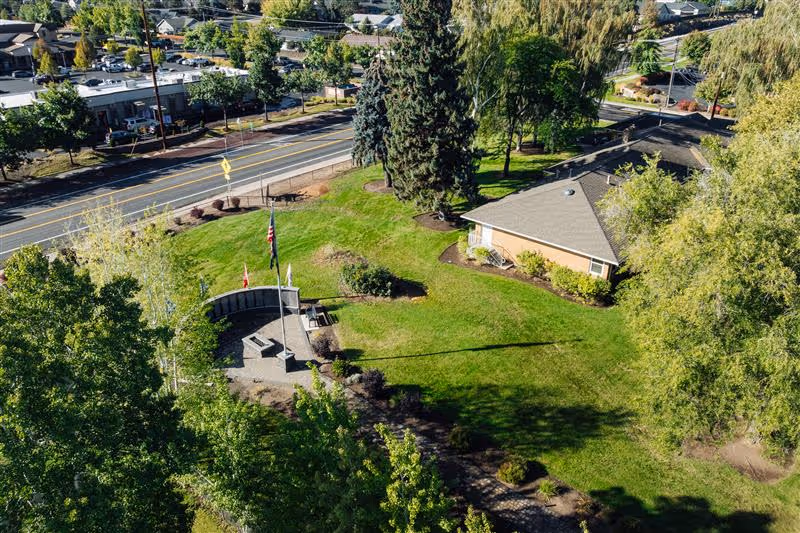 Aerial view of ClearPath Healthcare exterior with green lawn, trees, flagpoles, and road.