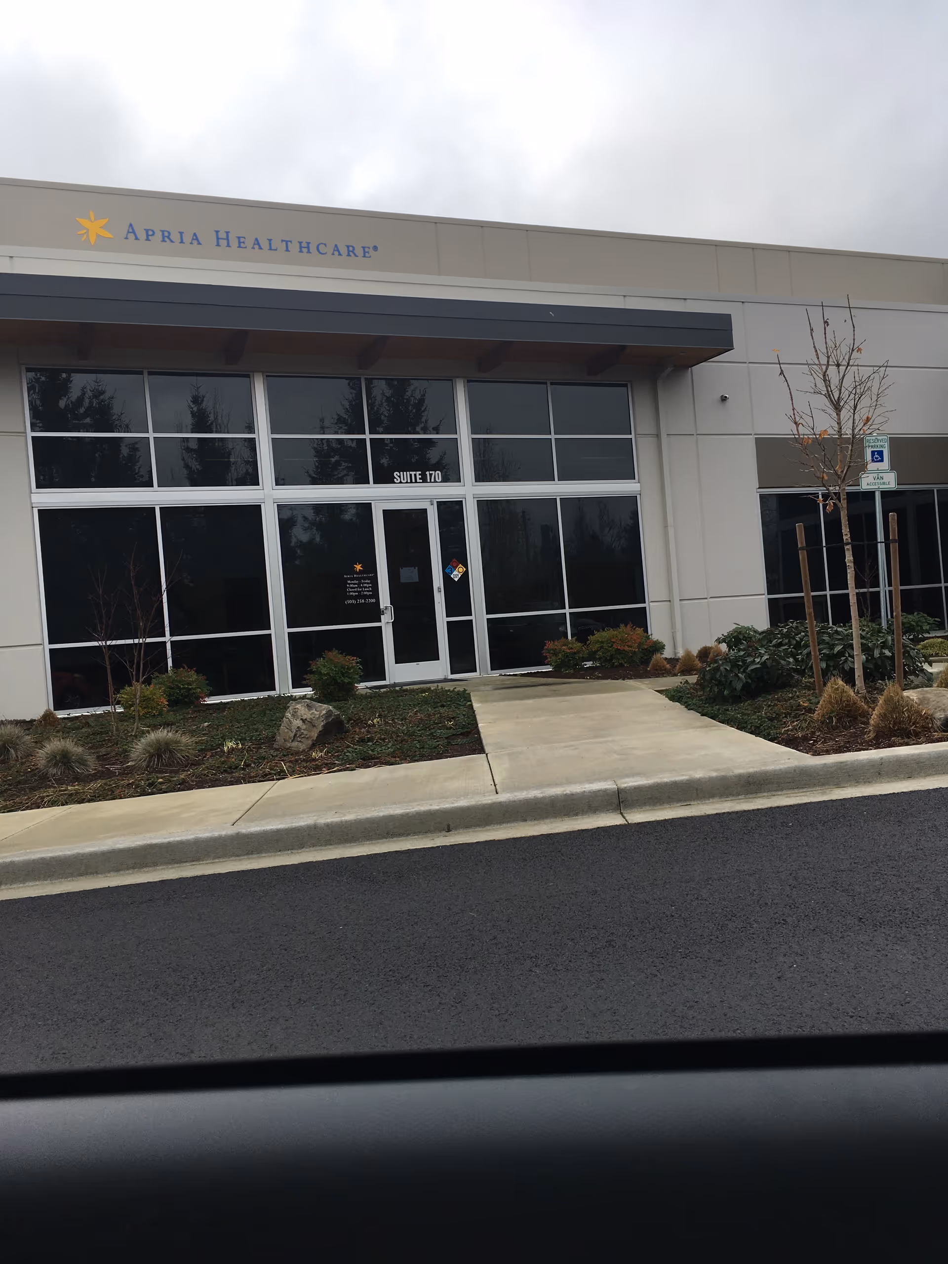 Front view of an Apria Healthcare storefront with glass entry doors.