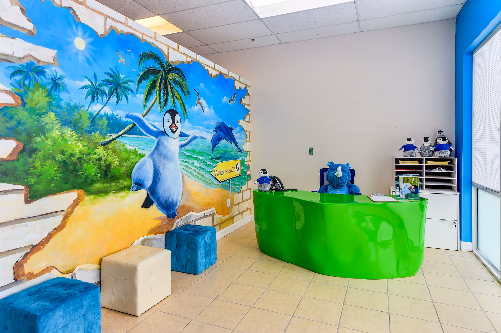 Bright interior reception area with a lime-green curved desk and tropical mural.