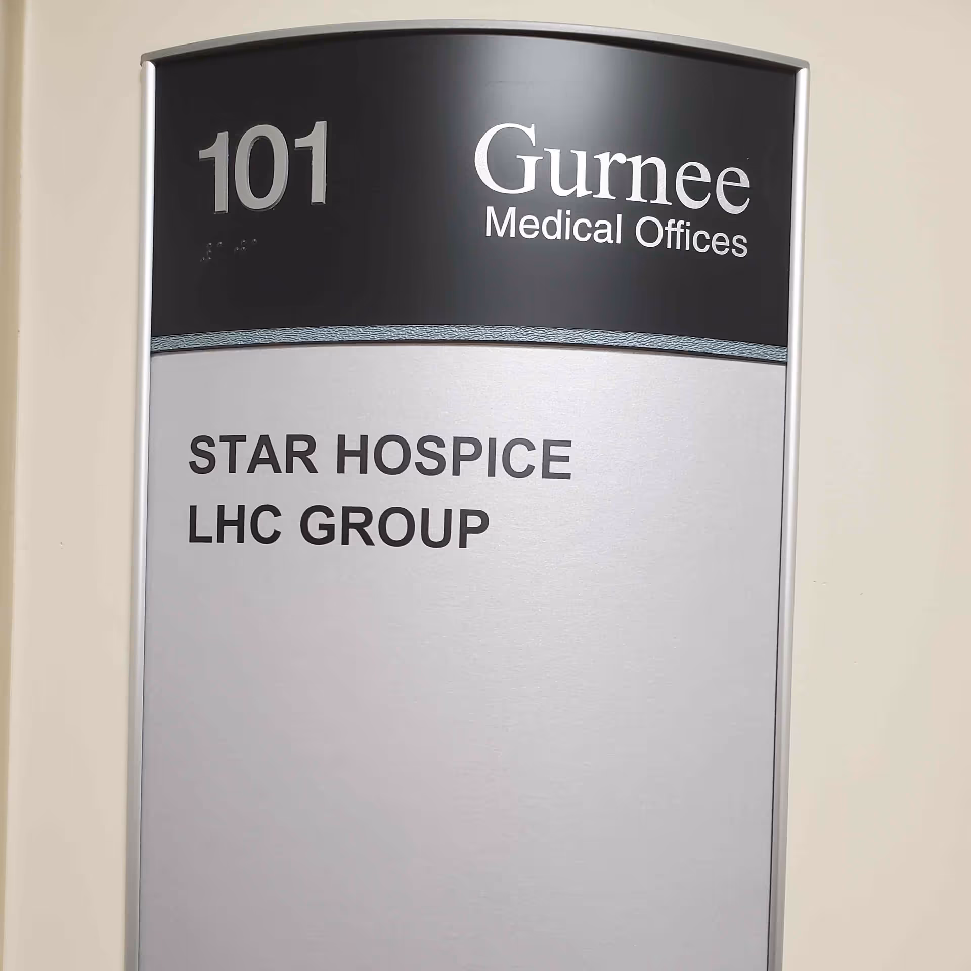 Indoor wall sign reads STAR HOSPICE LHC GROUP in a medical office hallway