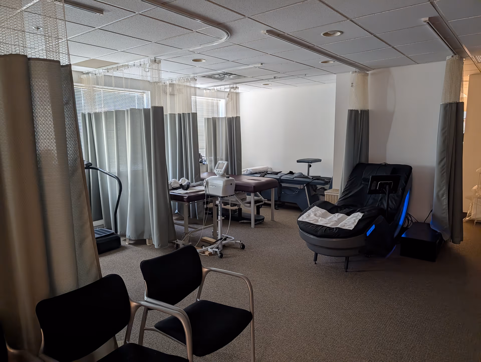 Wound care examination area with privacy curtains and medical treatment chairs.