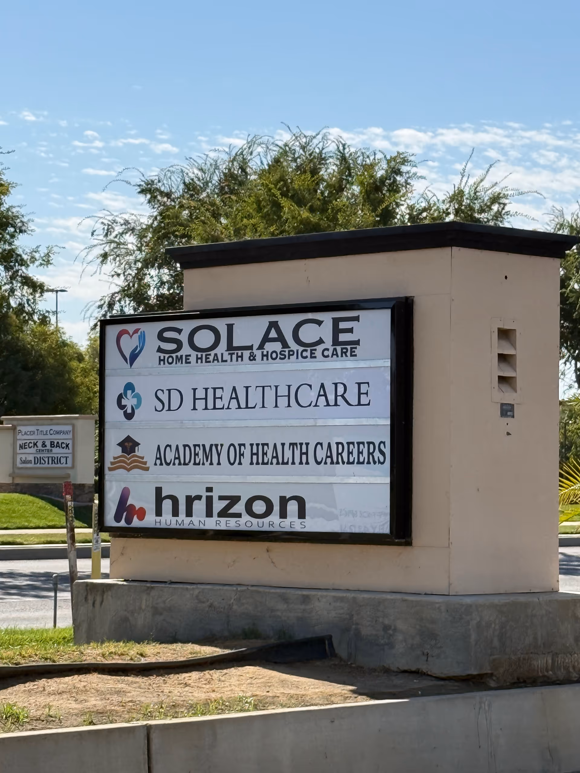 Exterior sign on a stone pedestal listing Solace Home Health & Hospice Care.