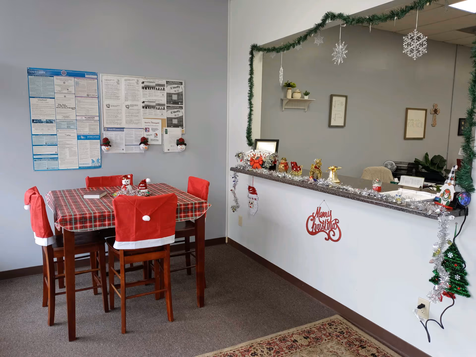 Holiday themed senior living dining area with table, chairs, and a decorated reception counter.