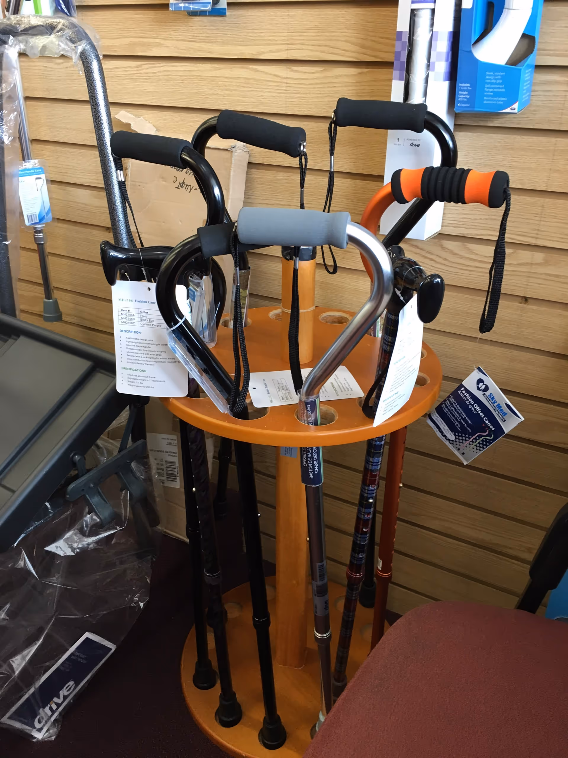 Display stand with multiple canes and walking aids in a store interior.