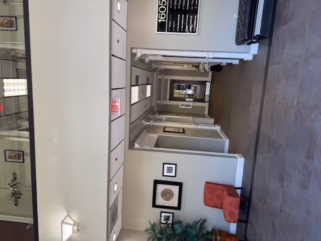 Long interior hallway of BAYADA Adult Nursing with doors, seating area, and wall decor.