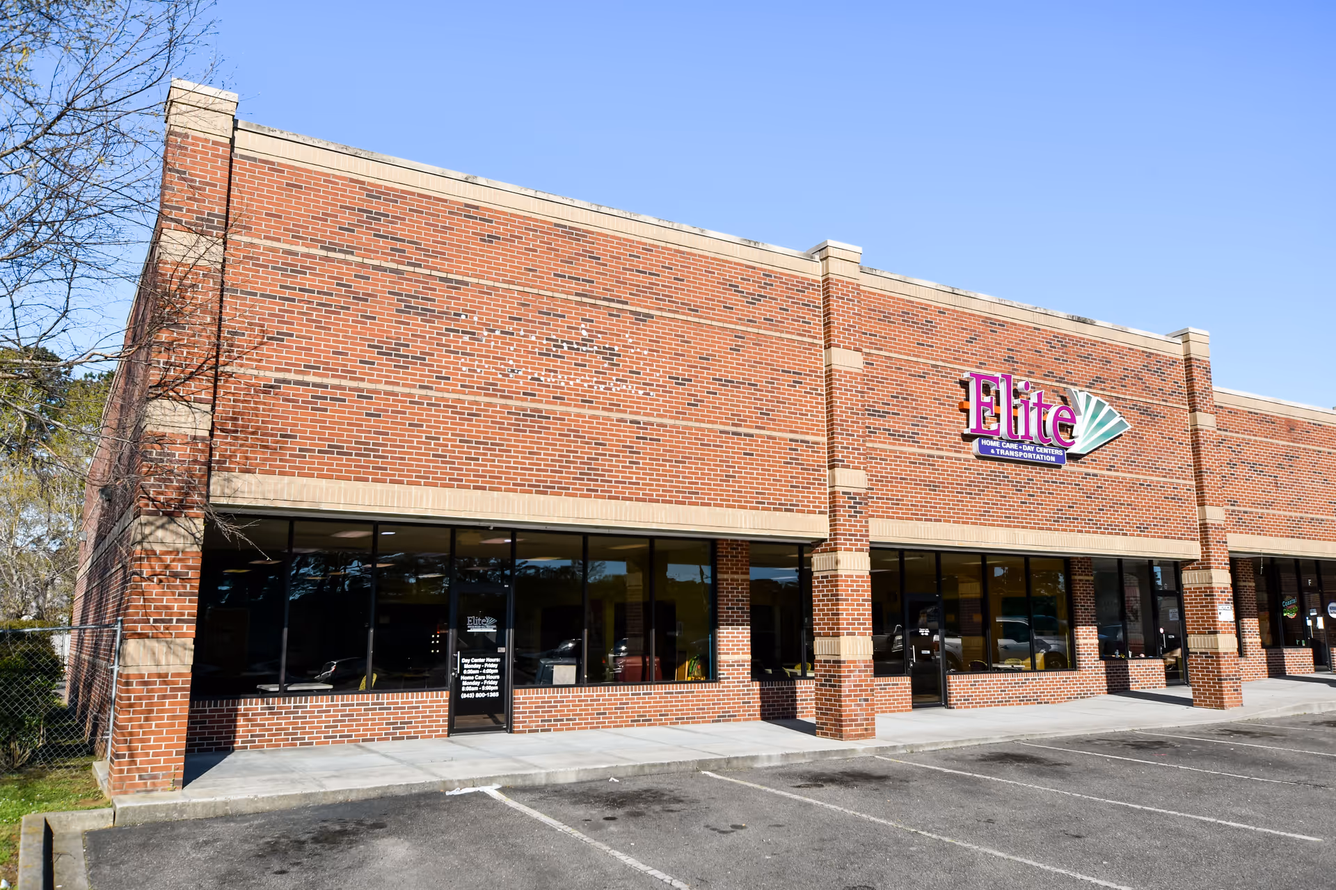 Brick building exterior with large storefront windows and an Elite sign.