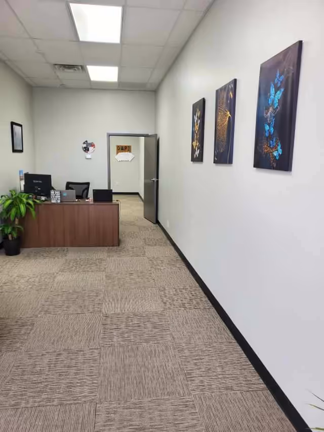 Reception hallway at St. Croix Hospice with desk, plants, and wall art.