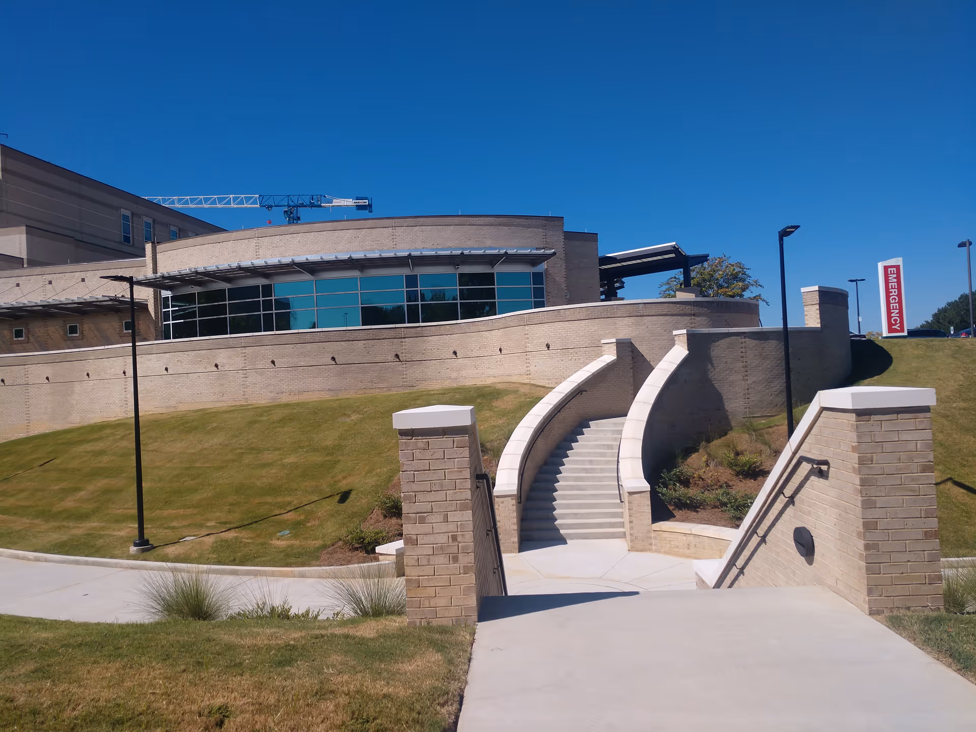 Curved brick entrance with stairs leads to the Cullman Regional Medical Center exterior.