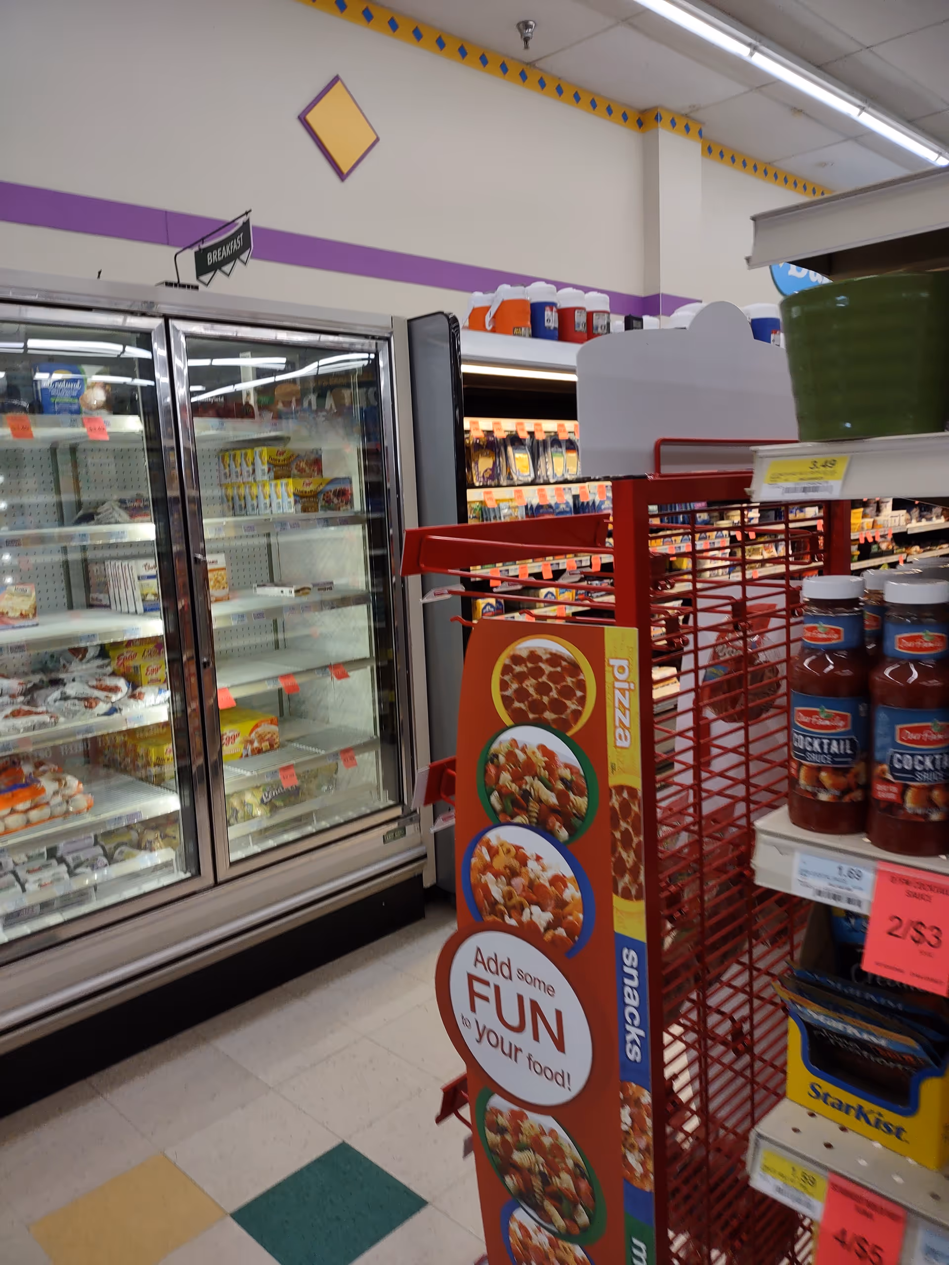 Interior view of a Discount Drug Mart grocery section with refrigerated cases and a red display.