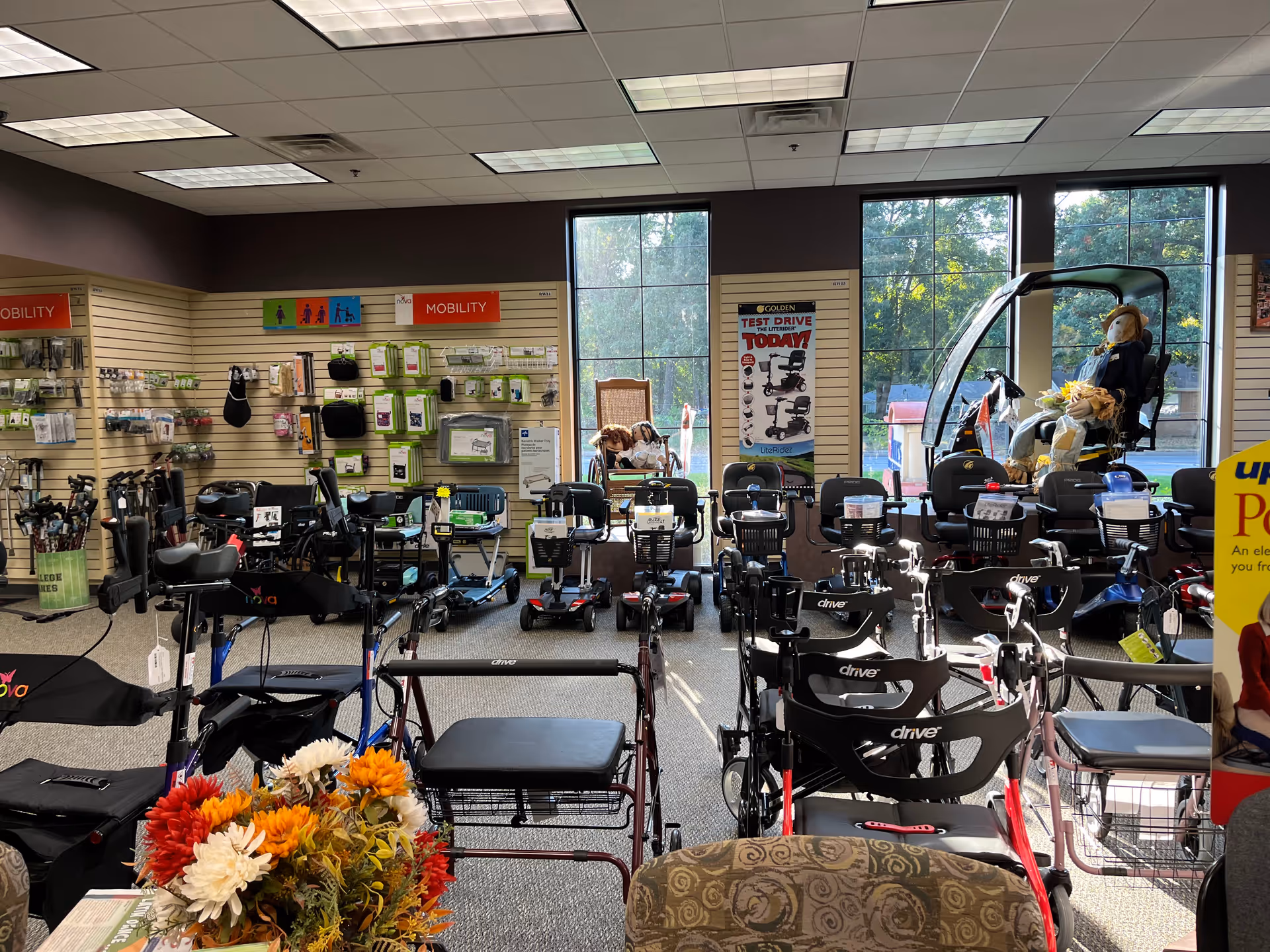 Interior showroom displaying multiple mobility scooters, walkers, and related medical devices.