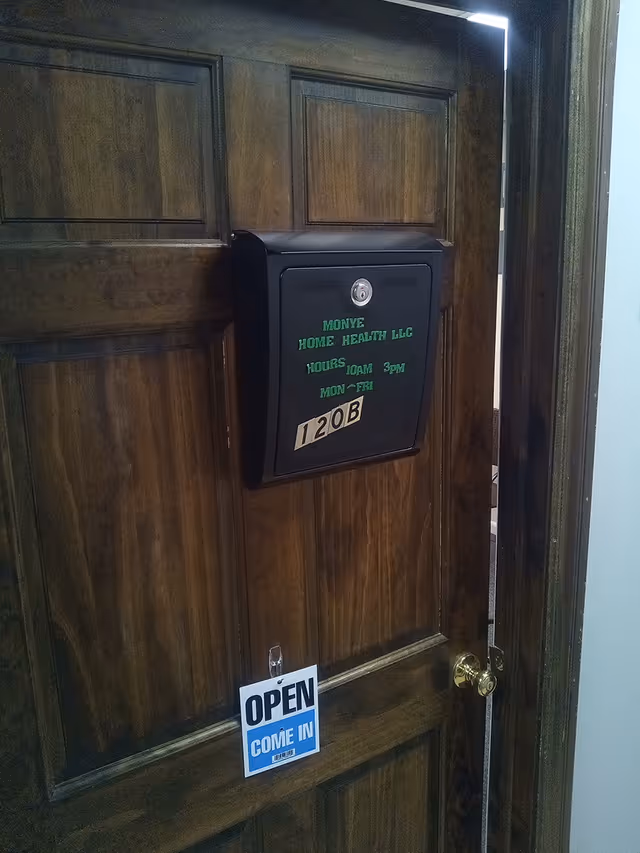 Wood-paneled interior door with a mailbox-style lockbox and open sign.