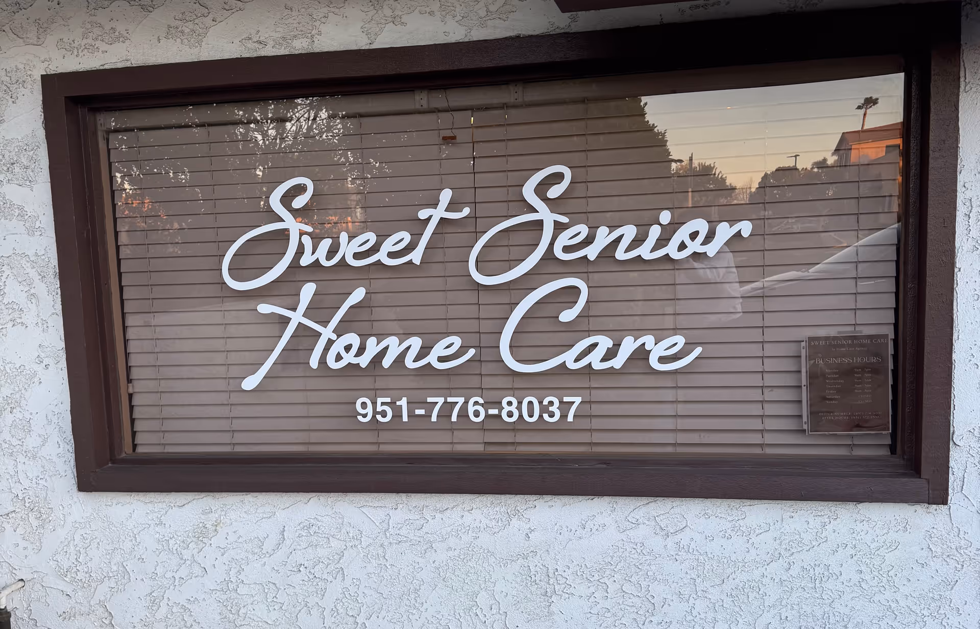 Window sign displays Sweet Senior Home Care with a phone number.