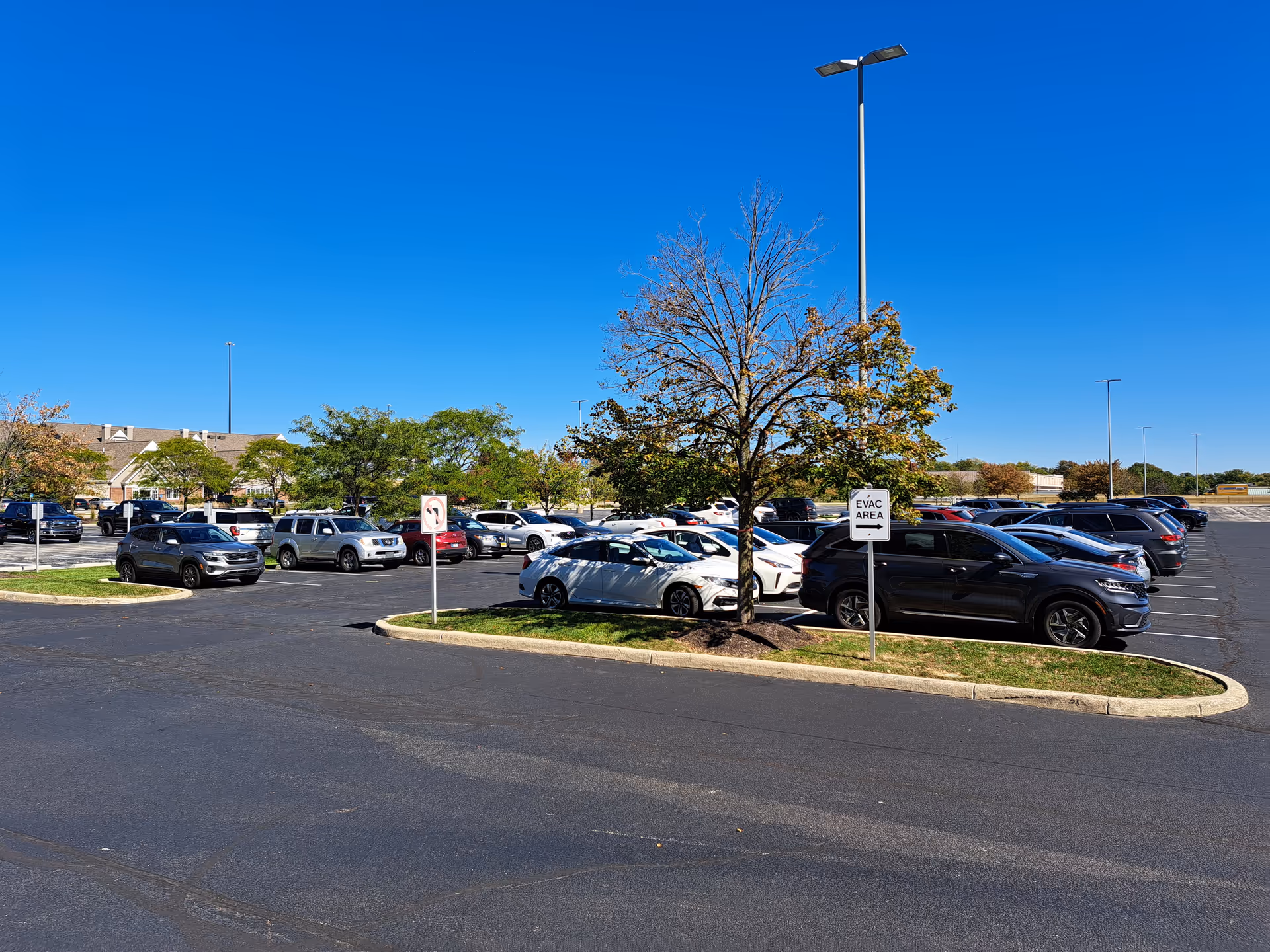 Parking lot in front of St. Croix Hospice with many cars and clear blue sky.