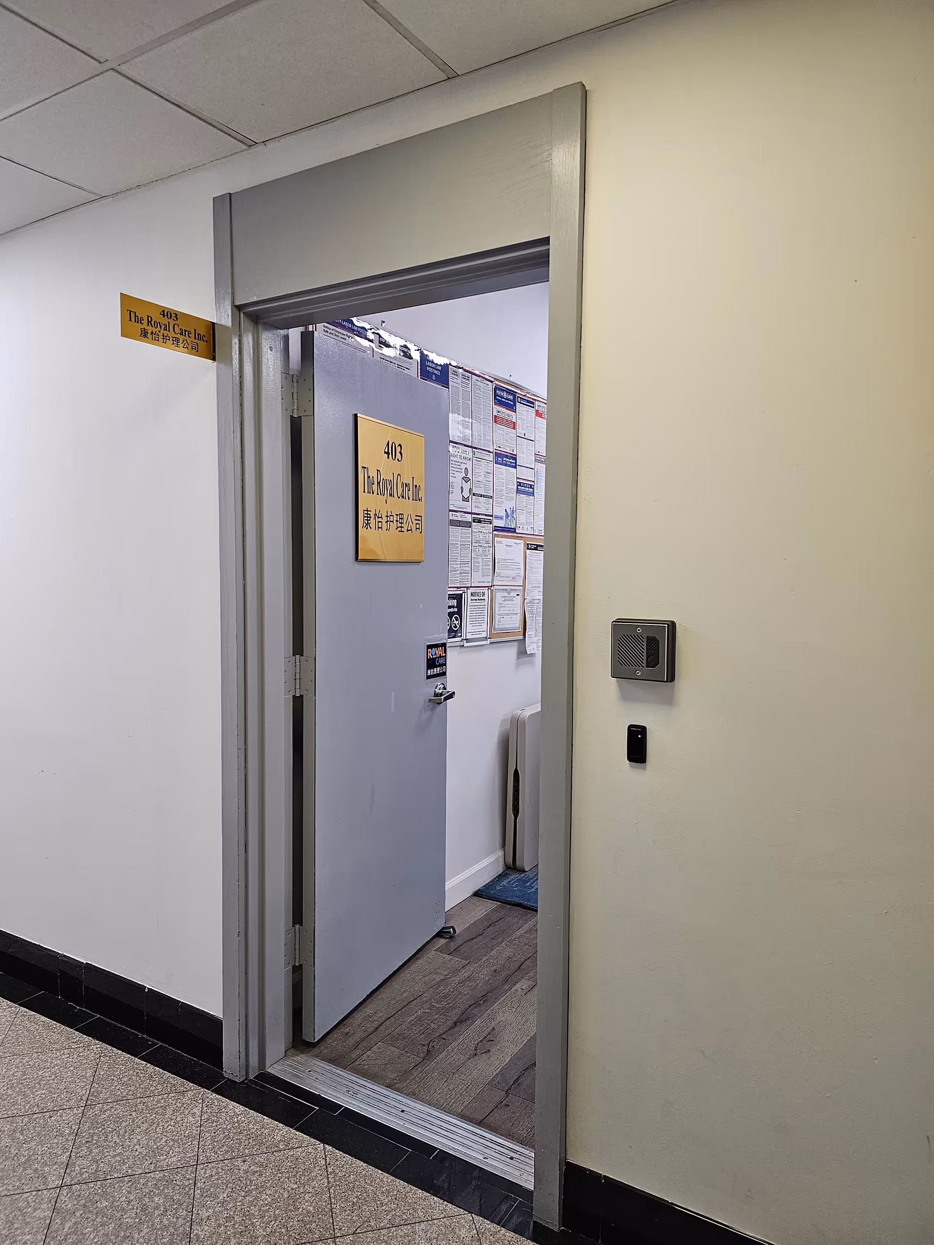 Open doorway to room 403 in The Royal Care facility, hallway with posted notices