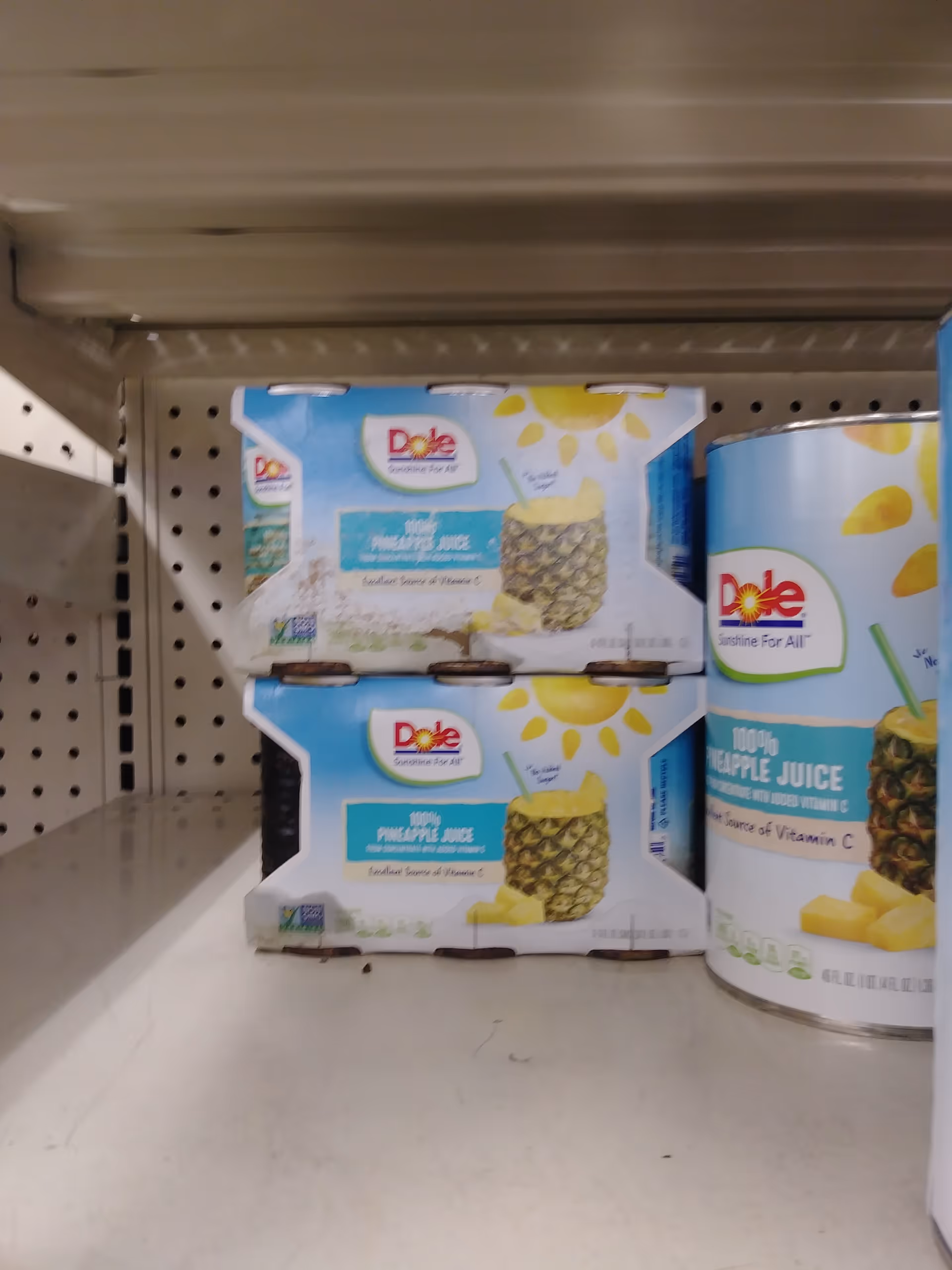 Aisle shelf at Discount Drug Mart displays Dole pineapple juice cartons.