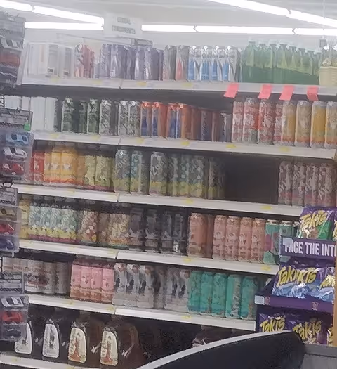 Interior aisle of Discount Drug Mart with shelves stocked with colorful bottled drinks.