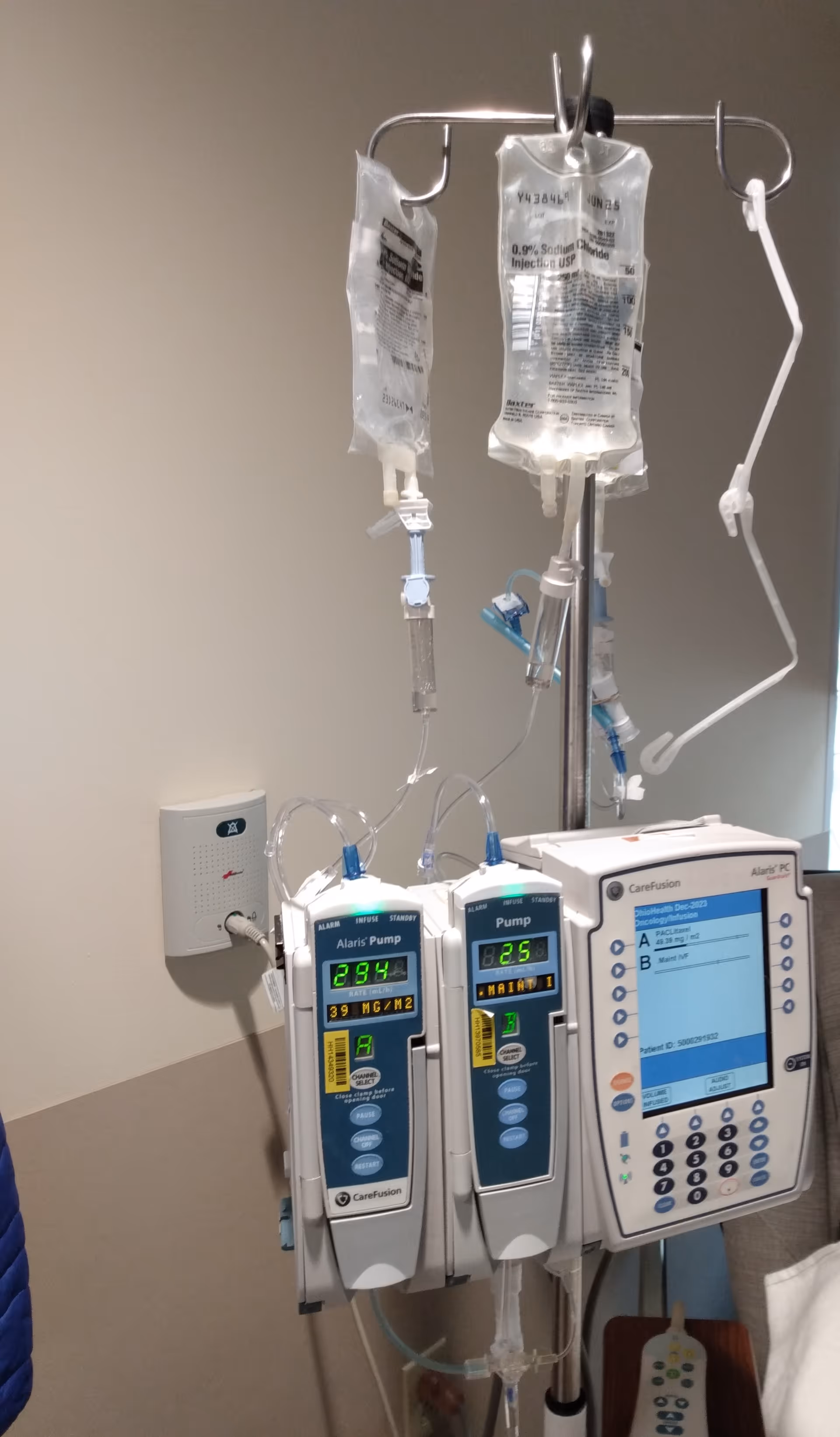 IV bags and infusion pumps mounted on a stand in a clinical infusion room.
