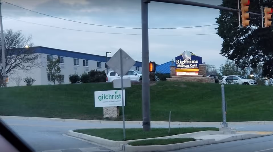 Exterior view of Gilchrist Center Towson with signage and parked cars.