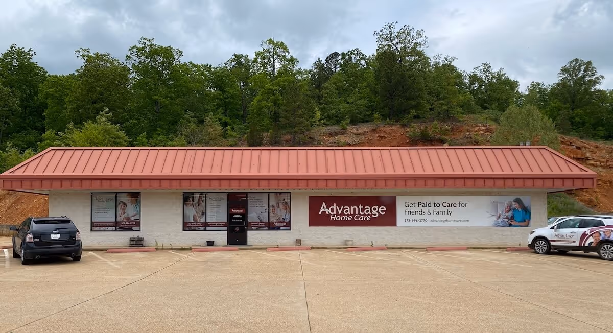 Exterior view of Advantage Home Care building with a red metal roof and parking lot.