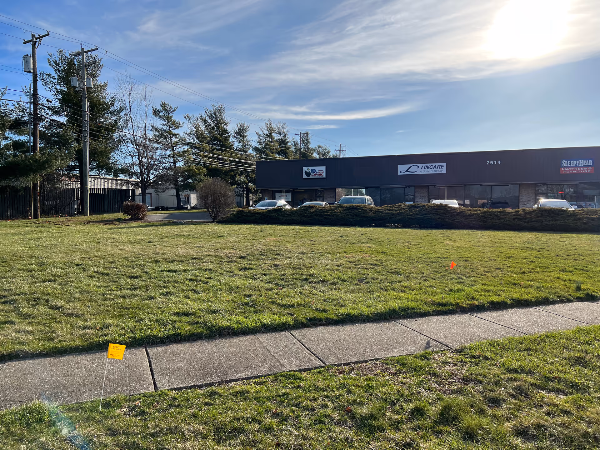 Exterior view of a LINCARE senior living facility with a grassy lawn and parking lot.