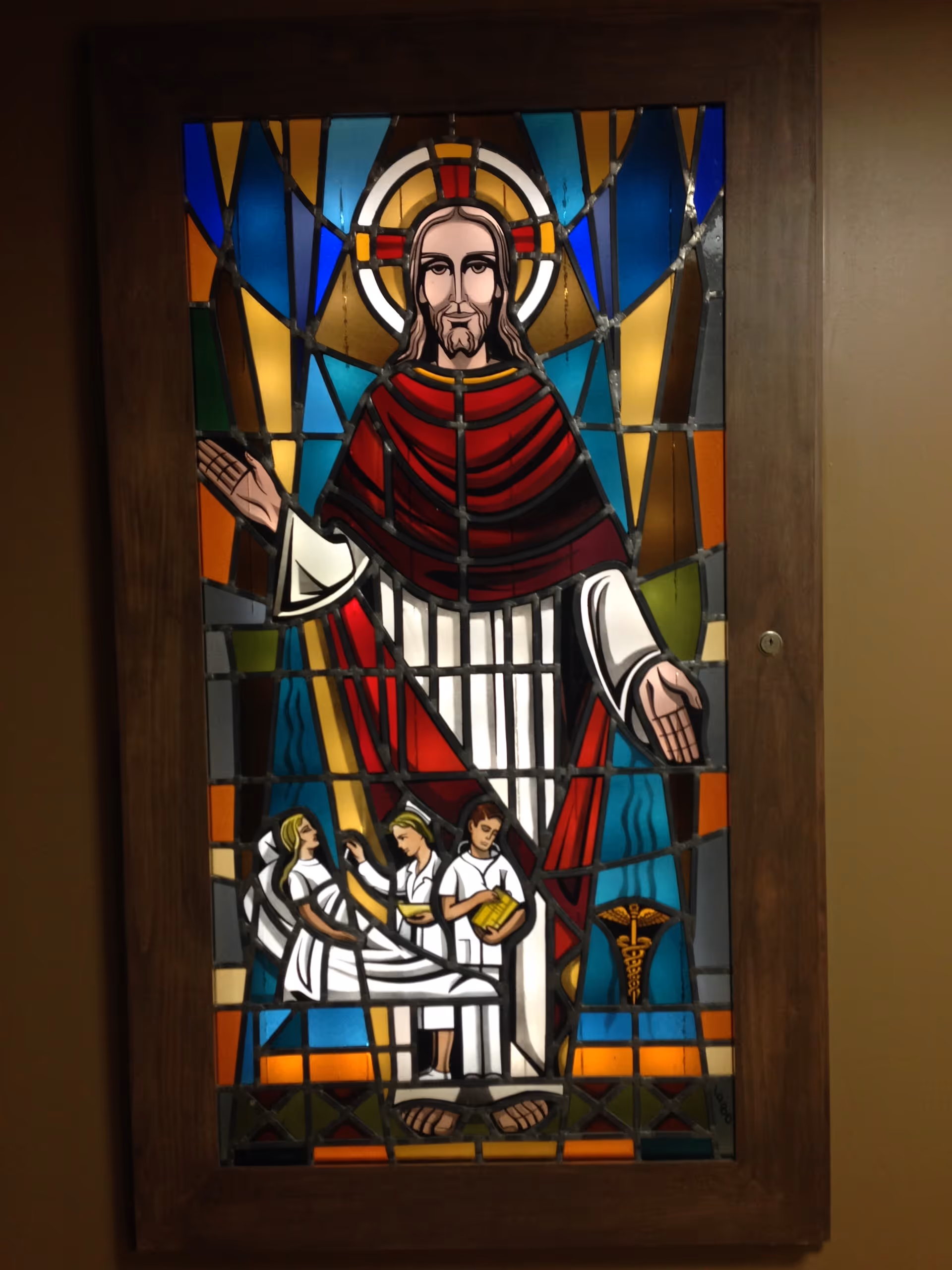 Stained glass panel depicting Jesus with followers framed in a wooden door