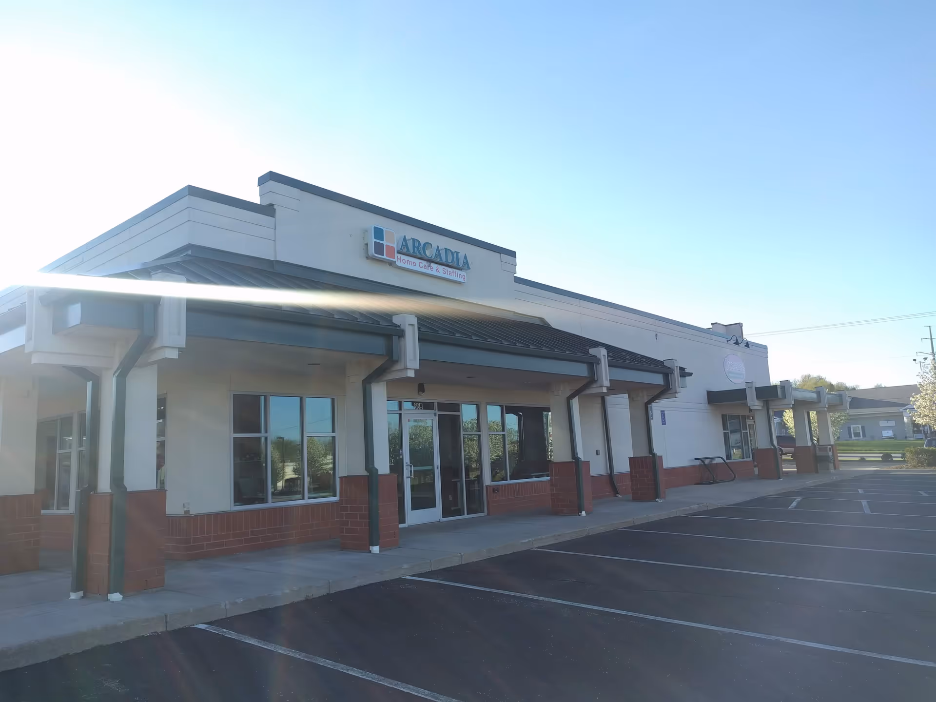 Exterior view of Arcadia Home Care and Staffing facility with parking lot and entrance.