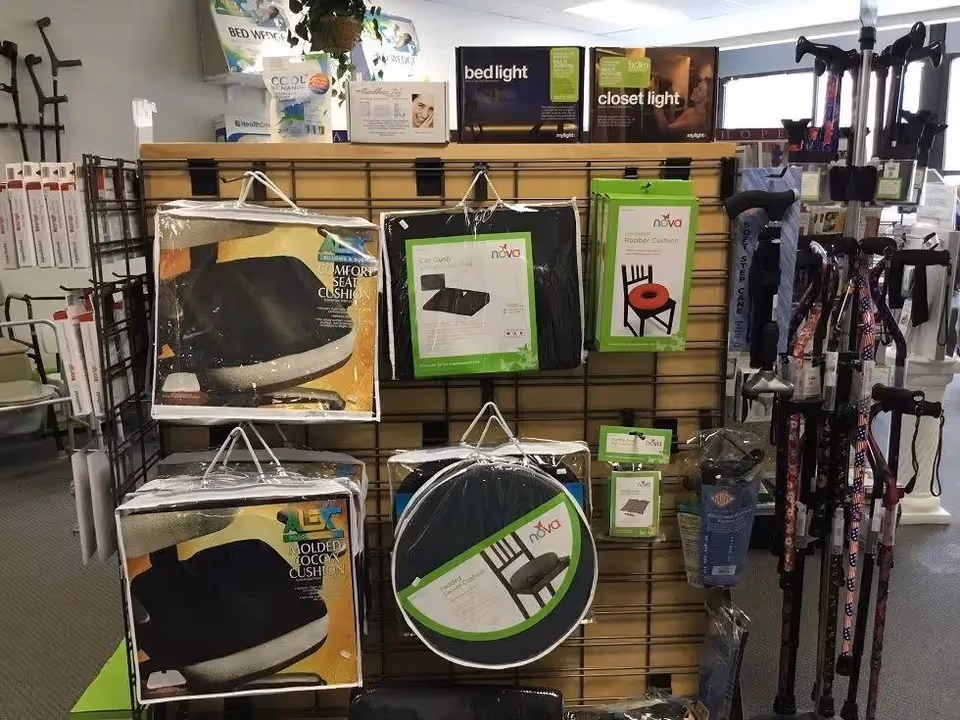 Indoor display of mobility aids and cushions on racks in a medical equipment shop.