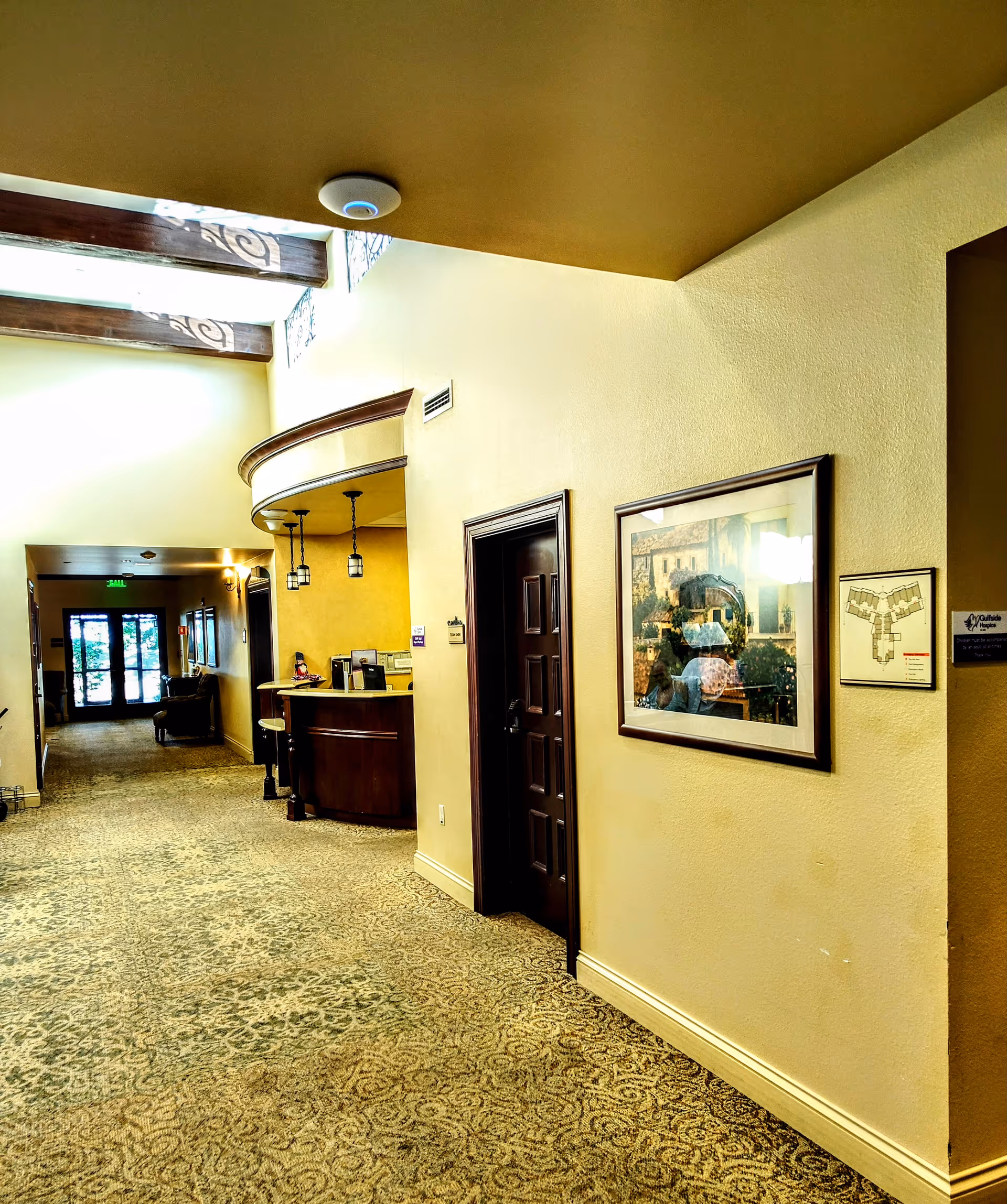Interior hallway of Gulfside Healthcare Services with a reception desk and framed artwork.