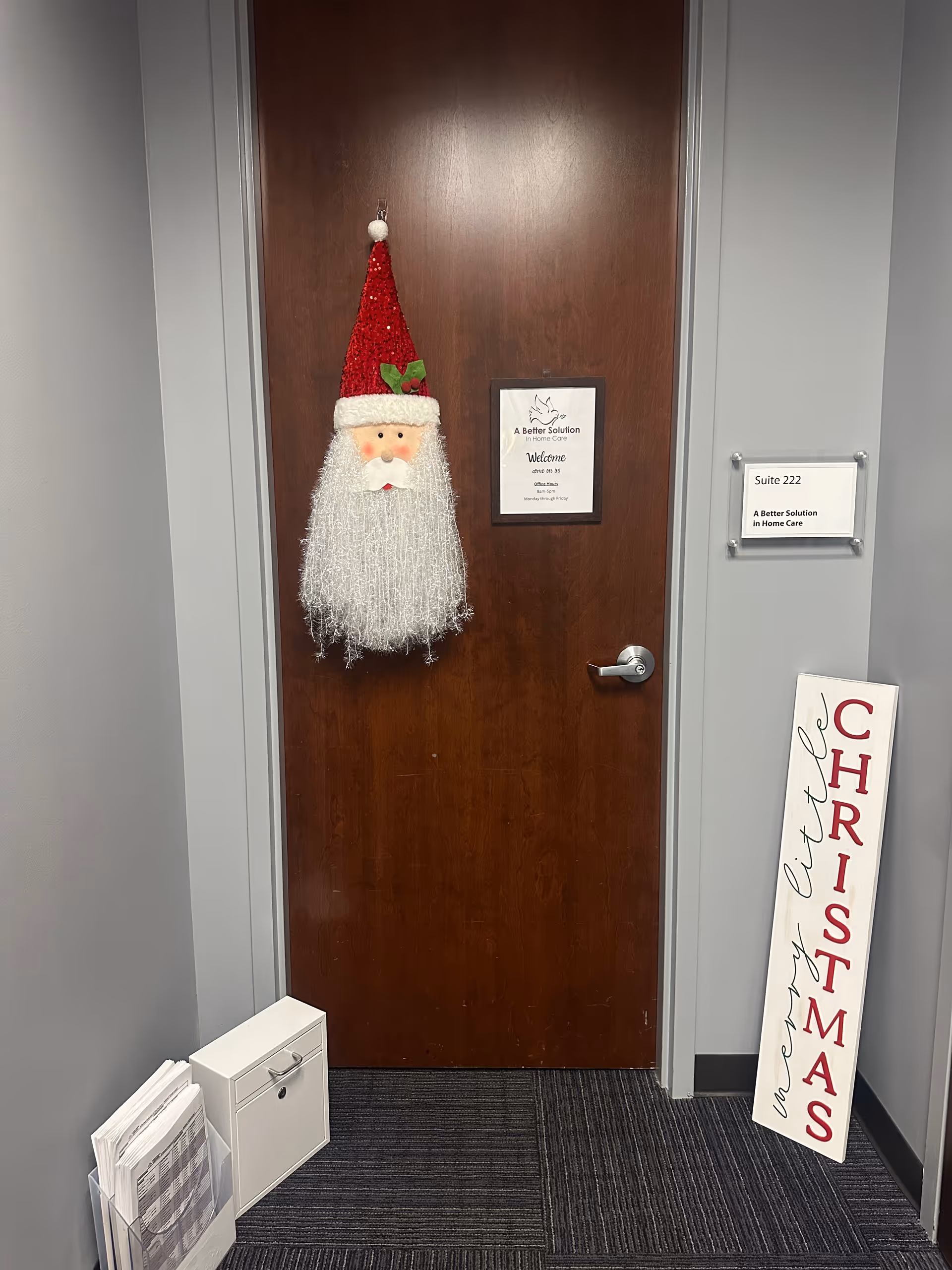 A hallway door in a home care facility decorated with Santa and Christmas decor.